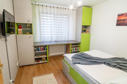 a bedroom with green walls and a bed with a window at Mirror Loft - Coresi District in Braşov