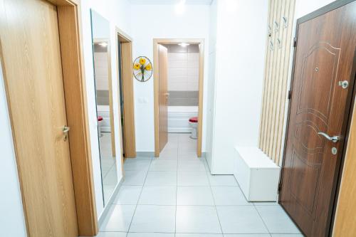a corridor of a bathroom with a toilet and a door at Mirror Loft - Coresi District in Braşov