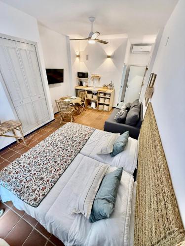 a bedroom with a large bed and a living room at Suite Triana in El Rocío