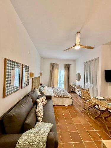 a living room with a couch and a bed at Suite Triana in El Rocío