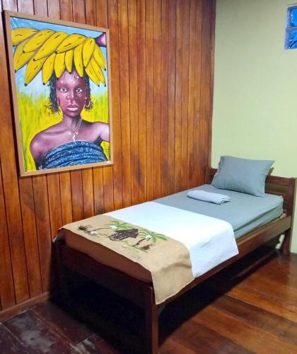 a bed with a picture of a woman with bananas on her head at Kemmiu Guest House Sao Tome in São Tomé