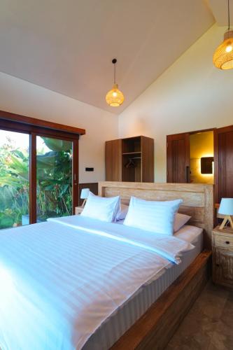 a large bed in a bedroom with a fishtank at INNerpeace Bali in Darmasaba