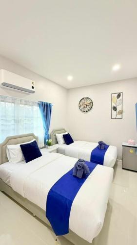 two beds in a room with blue and white at I Hug Homestay ไอฮัก ที่พักเชียงใหม่ in Ban Thap Dua