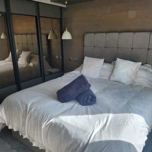 a large white bed with two blue pillows on it at 10 Sunset view in Scunthorpe