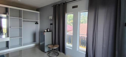 a room with a window and a table and a stool at Restu Chalet Tioman in Tioman Island