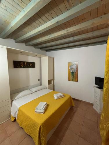 a bedroom with a bed with a yellow blanket at Residence Il Melograno in Lampedusa