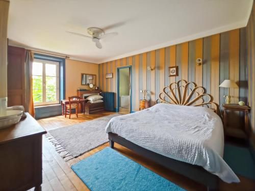 a bedroom with a large bed and a room with a desk at Villa Rhôna in Andancette
