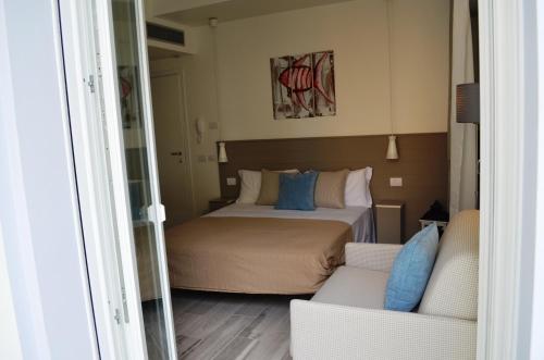 a small bedroom with a bed and a couch at Appartamenti Barzilai in Gabicce Mare