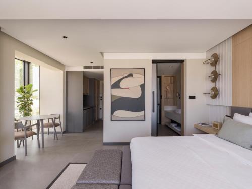 a bedroom with a white bed and a dining room at kolektif suites in Kyrenia