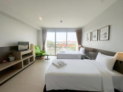 a hotel room with two beds and a television at Satun Le Grand - โรงแรม สตูล เลอแกรนด์ in Ban To La Nua