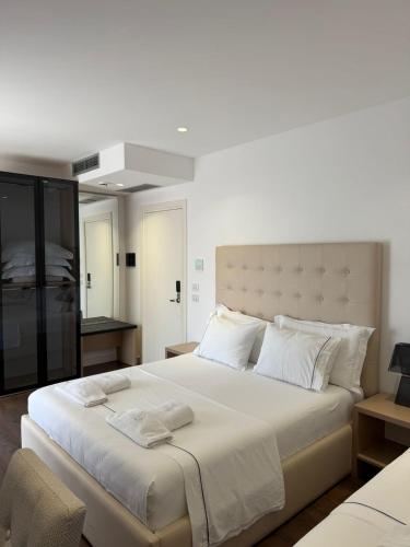 a bedroom with a large white bed with white pillows at Adria Palace Hotel & SPA in Durrës