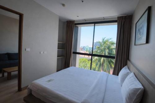 a bedroom with a bed and a large window at Sugar Palm Residence in Phuket