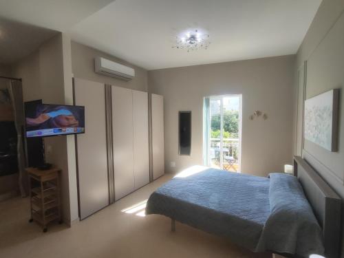 a bedroom with a bed and a flat screen tv at Ta'Roza Modern Apartment with Balcony & Distant Sea Views - Xaghra Gozo in Xagħra
