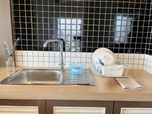 a kitchen sink with a faucet and a counter top at Satun Le Grand - โรงแรม สตูล เลอแกรนด์ in Ban To La Nua
