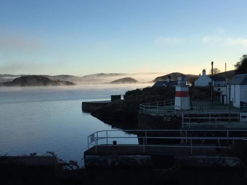 a lighthouse on the shore of a body of water at Crinan Hotel in Crinan