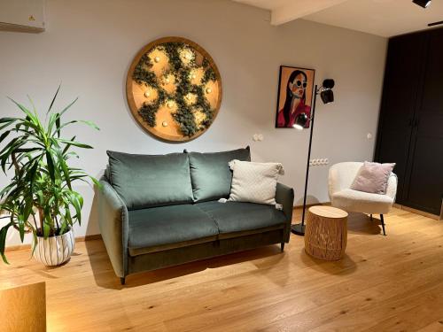 una sala de estar con un sofá verde y una silla en SoulLight Studio, en Tallin