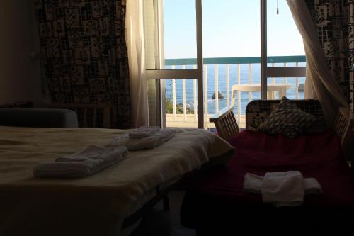 a hotel room with a bed and a large window at Praia Rocha Balcony First Line Beach View Studio in Praia da Rocha