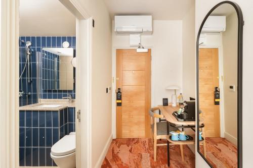 a small bathroom with a toilet and a table at voco London - Bloomsbury by IHG in London