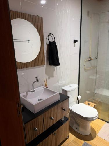 a bathroom with a sink and a toilet and a shower at Cabana Refúgio da Montanha in Alfredo Wagner