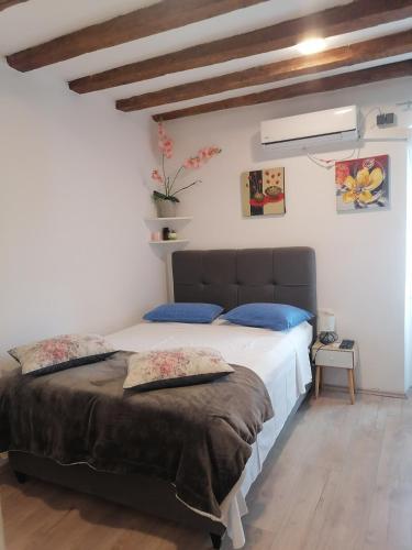 a bedroom with a large bed with blue pillows at D & G in Split