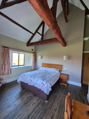 a bedroom with a bed and wooden floors at Padley Farm in Bradfield