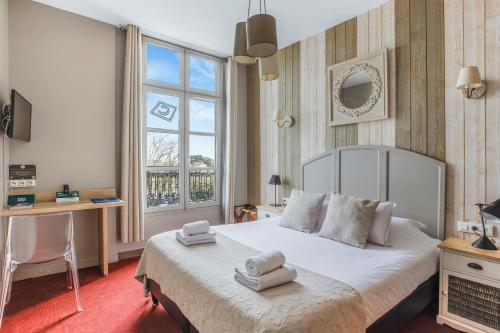 a bedroom with a bed with two towels on it at Logis Hôtel Restaurant Cristal in Saumur