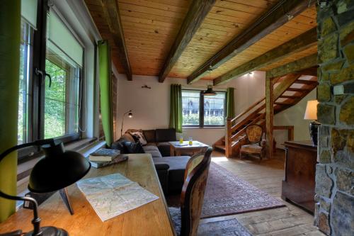 a living room with a couch and a table at Dom wakacyjny Chata Babci Wolf in Strzebowiska