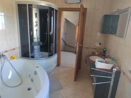 a bathroom with a tub and a shower and a sink at Villa Bella Vista - For up to 6 people Villa with Sea & Castle view in Črni Kal