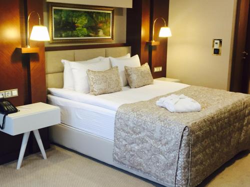 a hotel room with a large bed and a telephone at Vivaldi Park Hotel in Ankara