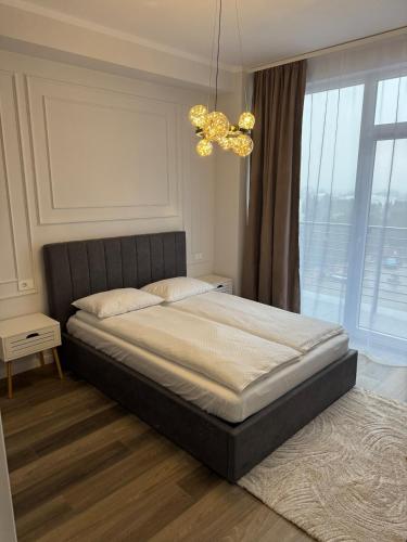 a bedroom with a large bed and a chandelier at Nordic Star in Rădăuţi