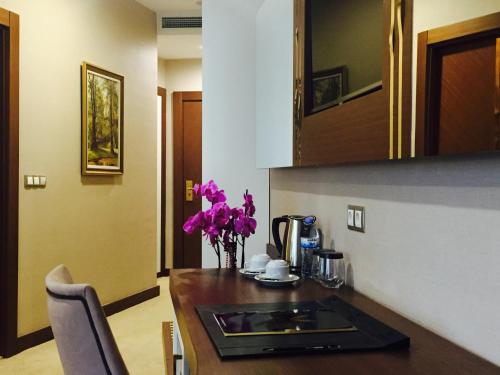 a kitchen with a sink and a vase of purple flowers at Vivaldi Park Hotel in Ankara