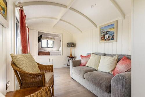 a living room with a couch and a bed at Unique Double Shepherd's Hut Hideaway - Pembrokeshire in Haverfordwest