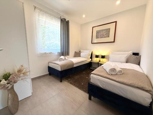 a bedroom with two beds and a window at Local-Lux Garden Residence A- 2 Bedrooms-Terrace in Kecskemét