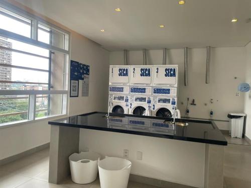 a laundry room with a washer and dryer on a counter at 1412 - Studio completo com varanda e vaga in São Paulo