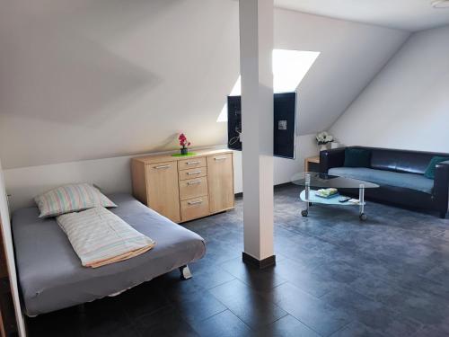 a bedroom with a bed and a couch at Ferienwohnung Mühlbach in Igensdorf