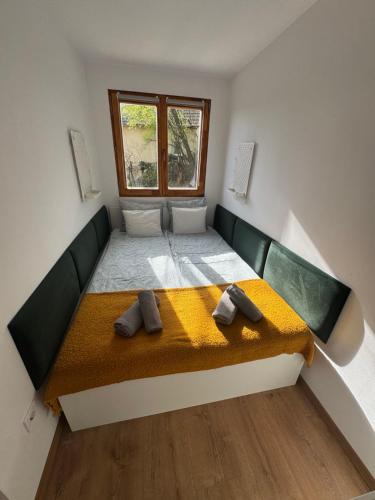 a small room with a bed with a window at Lépcsősház in Nagymaros