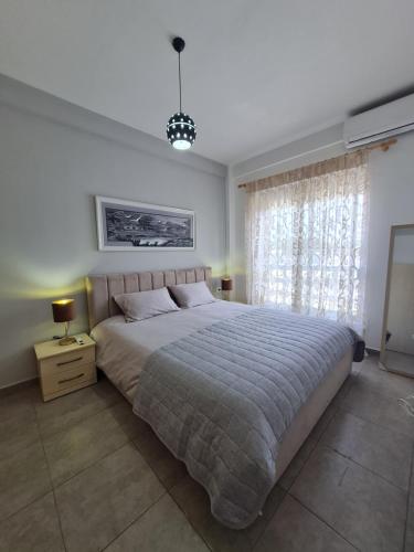 a bedroom with a large bed and a window at Gjiri I Lalzit apartament in Draç