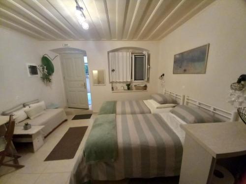 a large bedroom with a bed and a couch at Studio CASINELLA in Corfu