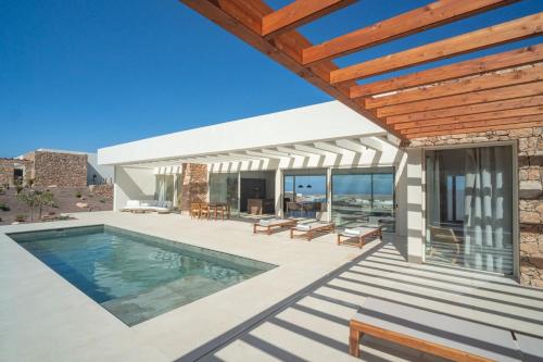 a house with a swimming pool and a patio at Villa James by Aura Collection in Tindaya