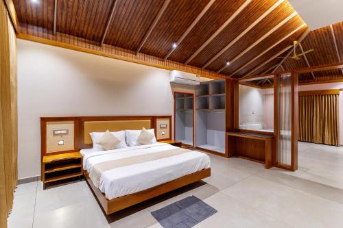 a bedroom with a large bed and a bathroom at Vynza Resort Vythiri in Vythiri