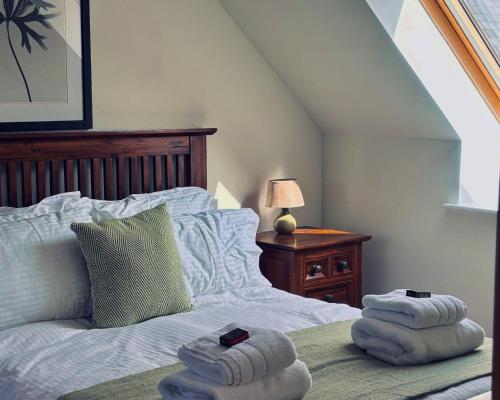 a bedroom with a bed with two towels on it at Bracken Cottage in Killean