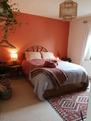 a bedroom with a large bed with red walls at Cozy Homestay in Rothesay