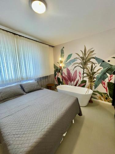 a bedroom with a large bed and a bath tub at Incrível apto com banheira e garagem perto de tudo in Florianópolis