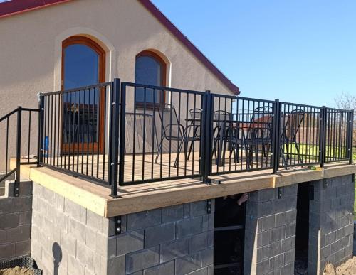 a balcony with chairs and tables on a house at Sklep Víno Strýček in Velké Bílovice