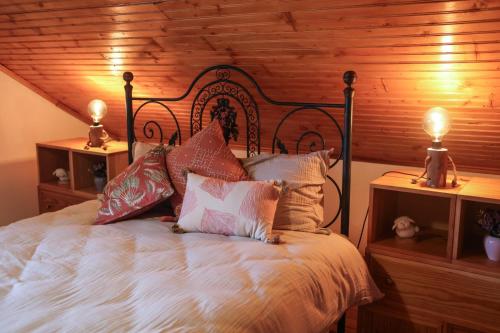 a bedroom with a large bed with two lamps on tables at Casa dos Avós in Parceiros da Igreja
