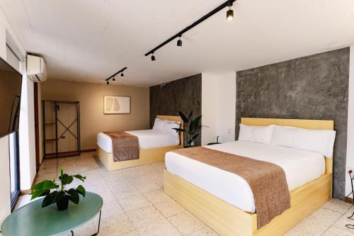 a hotel room with two beds and a table at Cardedeu Express Hotel in San Salvador
