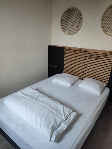 a large bed with white sheets and pillows at Appt climatisé vues sur mer in Fleury