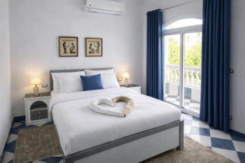 a bedroom with a bed with a heart pillow on it at Ali Baba Hotel in Luxor