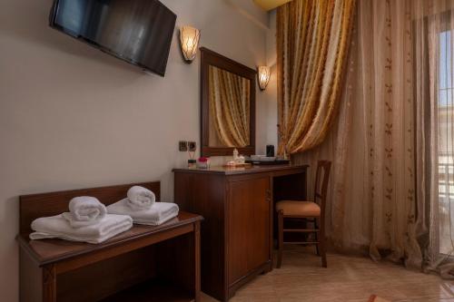 a hotel room with towels on a desk and a mirror at Filippos Hotel in Nea Moudania