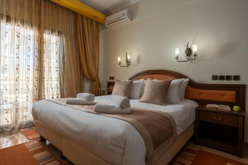a bedroom with a large bed with towels on it at Filippos Hotel in Nea Moudania